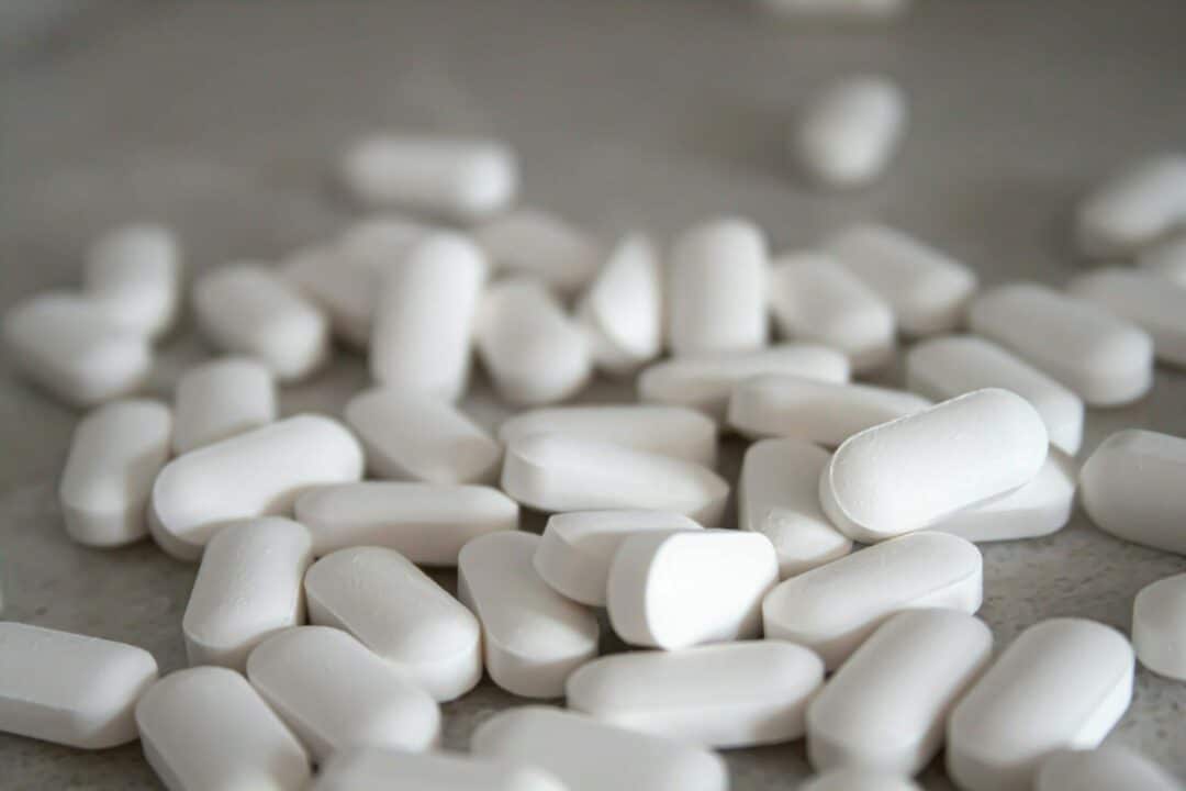 white pills on a brown surface